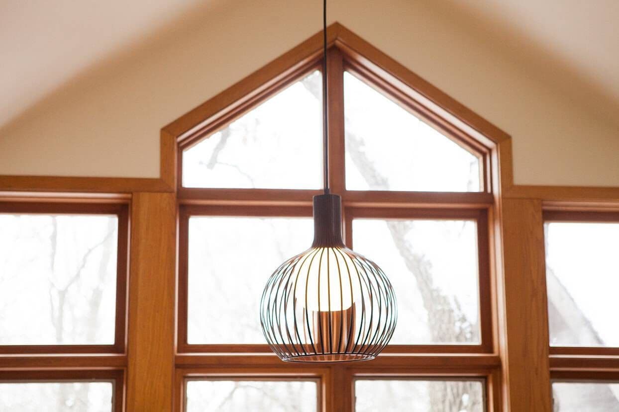 unique light hanging in front of windows