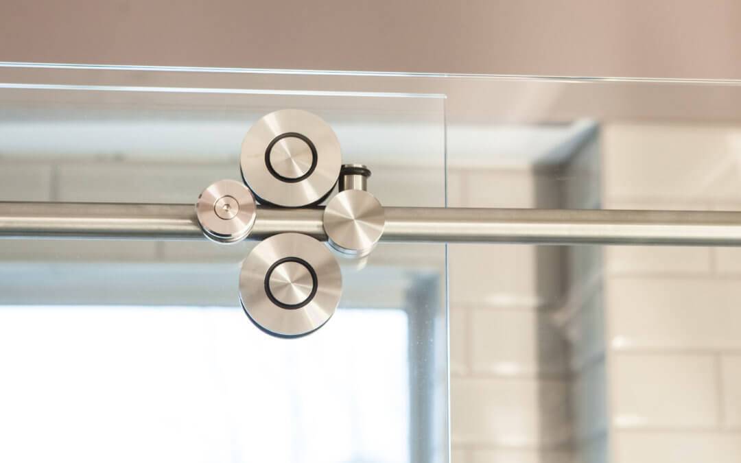 close up of the brushed hardware on a sliding glass shower door