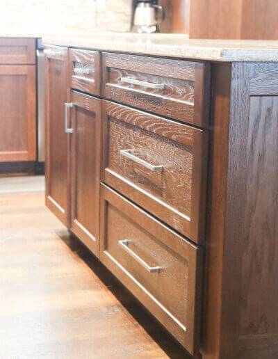 close up image of kitchen island on the dark wood drawers with silver pulls