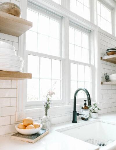 Sink with white countertops and bright large windows
